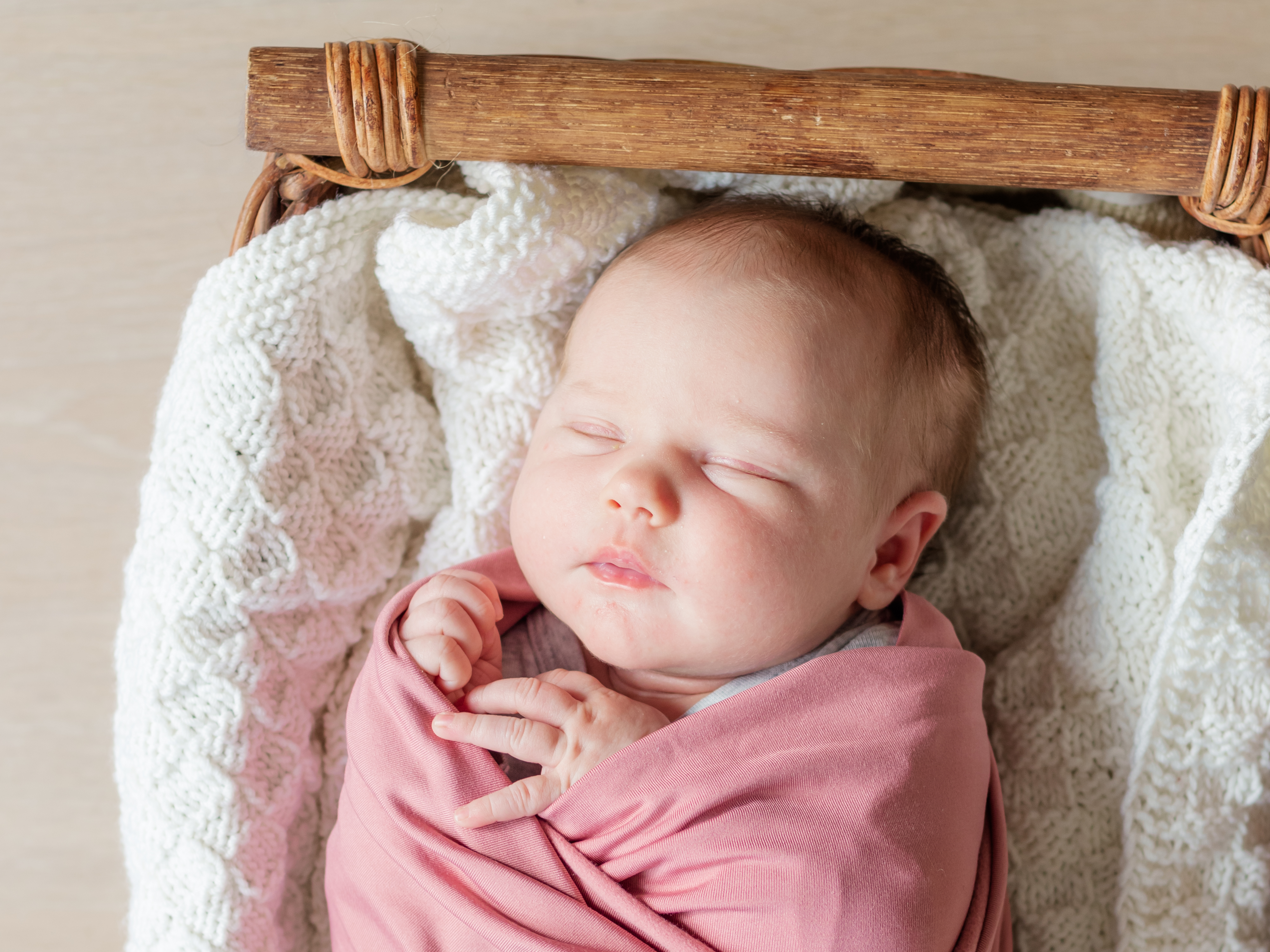 Newborn girl wrapped in pink, in a basket, newborn photographer in Del Norte