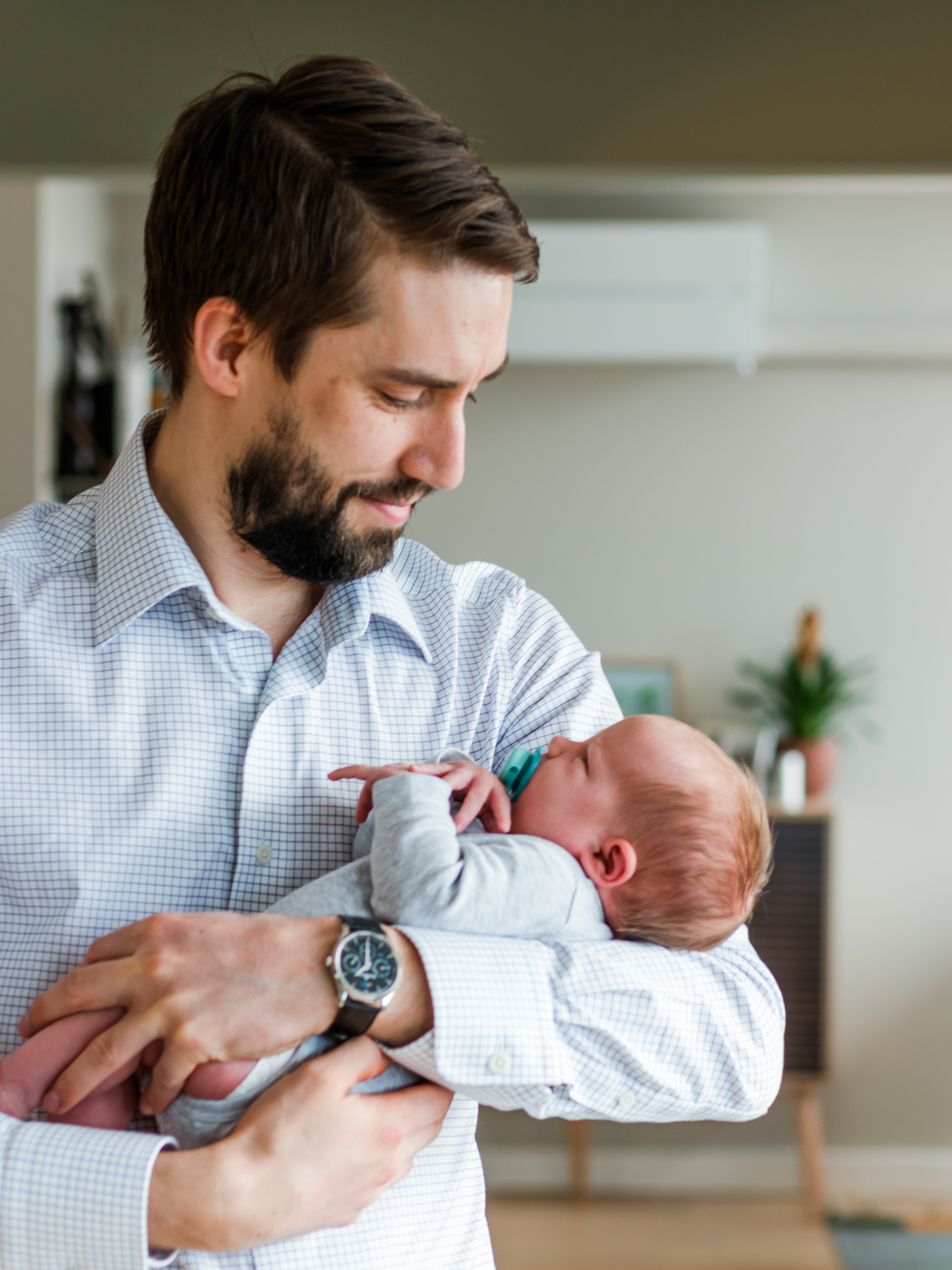 Man smiling at baby in arms, newborn photography session