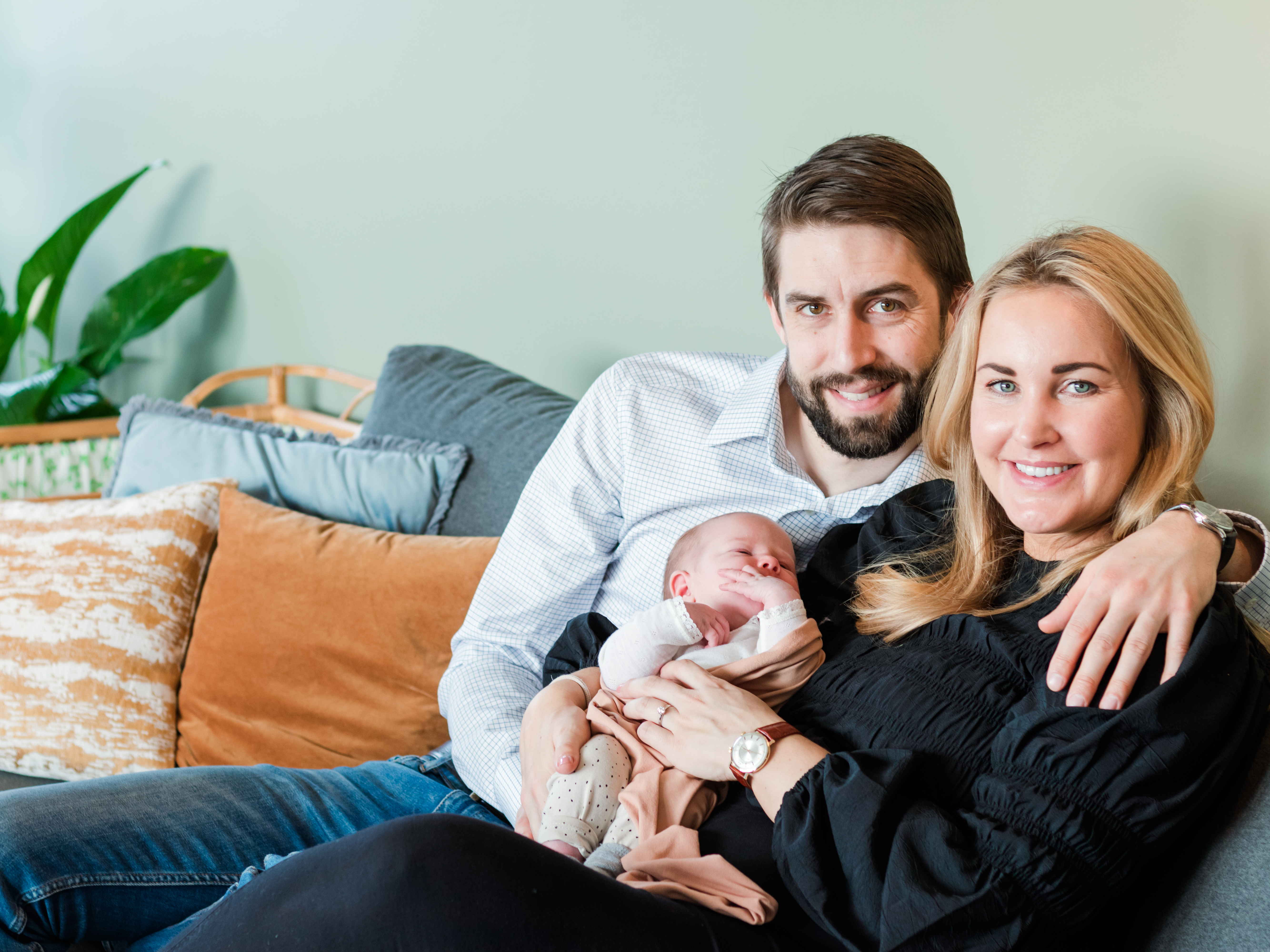 Couple on couch holding infant, newborn photographer Creede, Colorado, near me