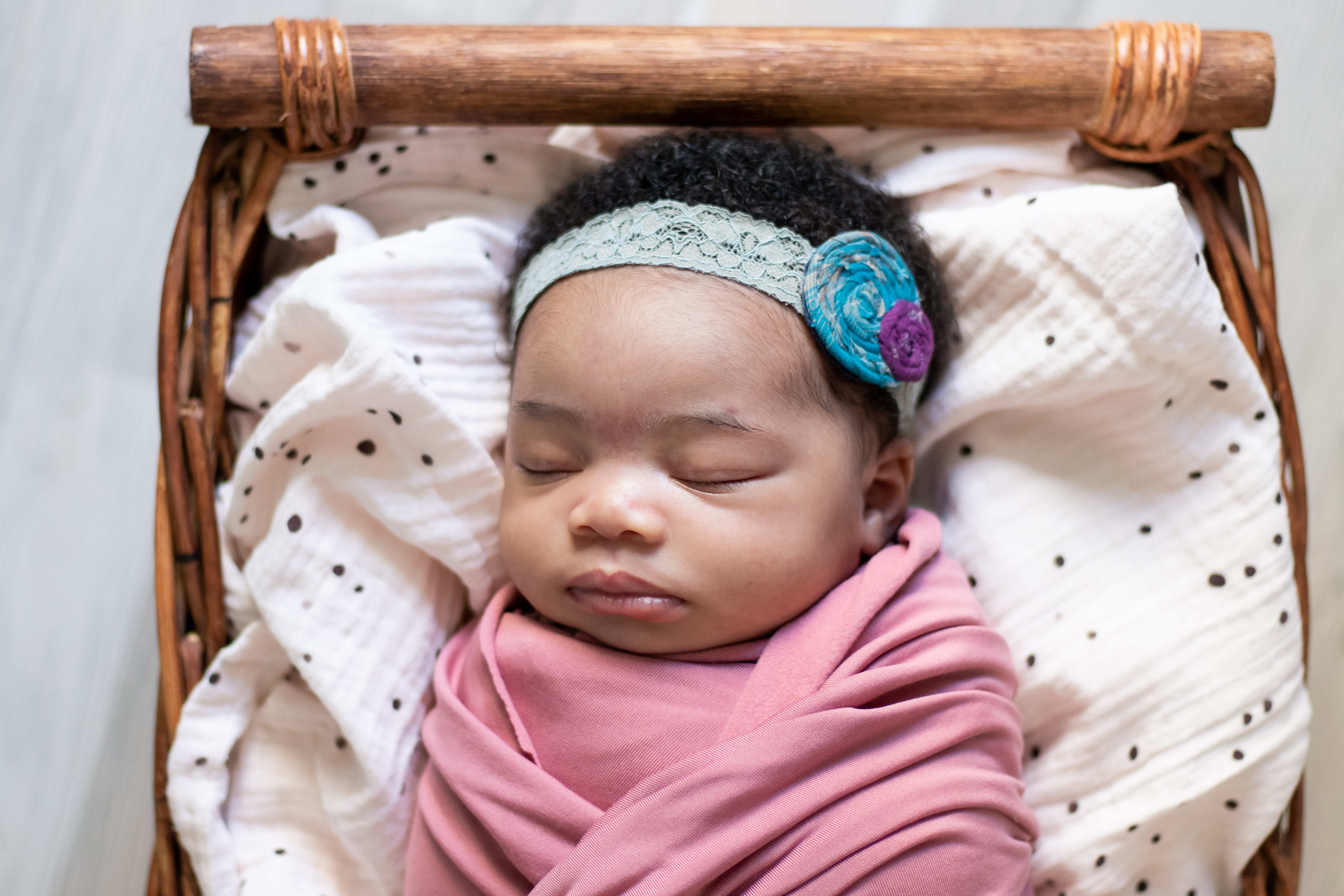 Baby girl in basket, sleeping with headband, newborn photographer near me