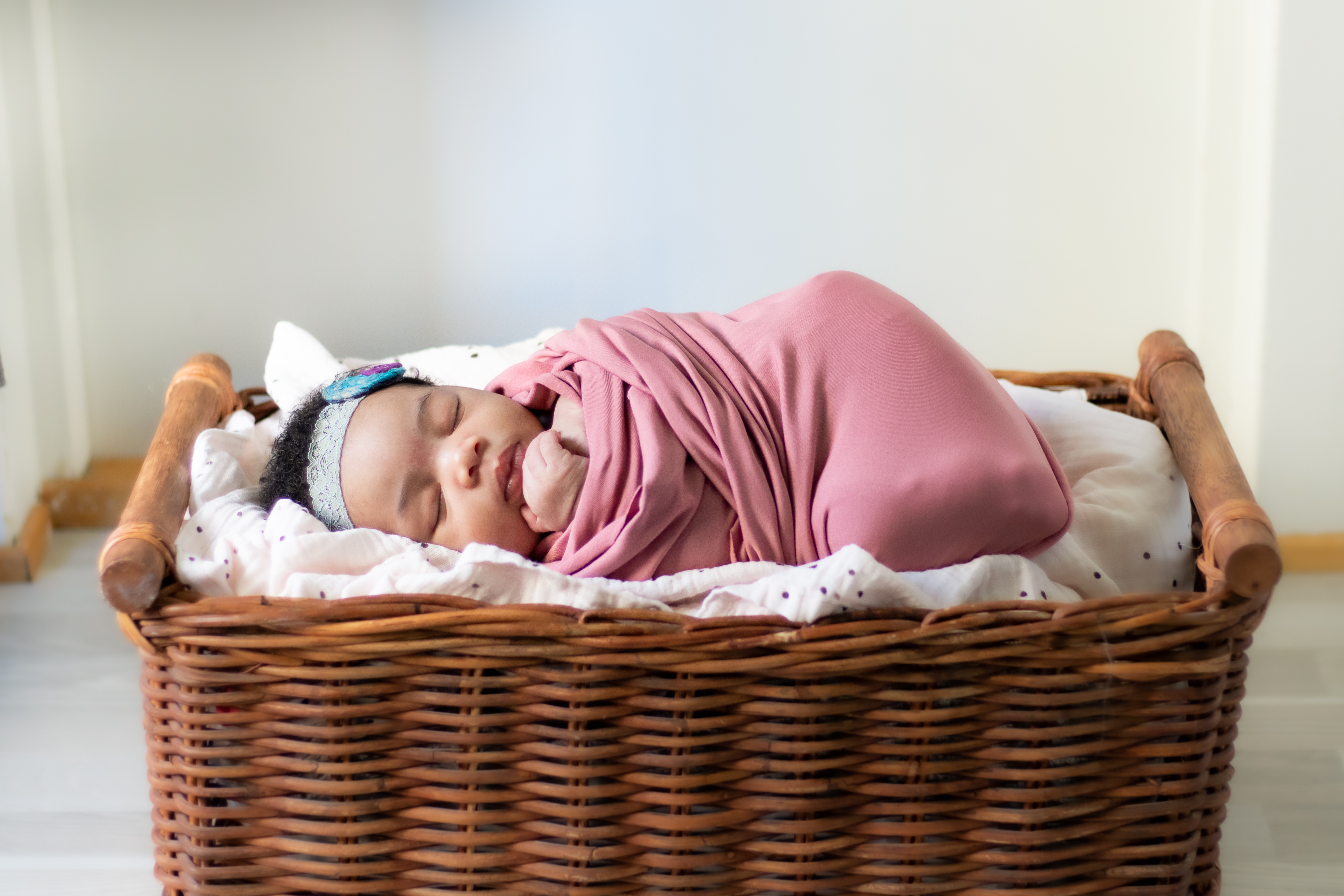Newborn swaddles and laying in basket, newborn photography lifestyle