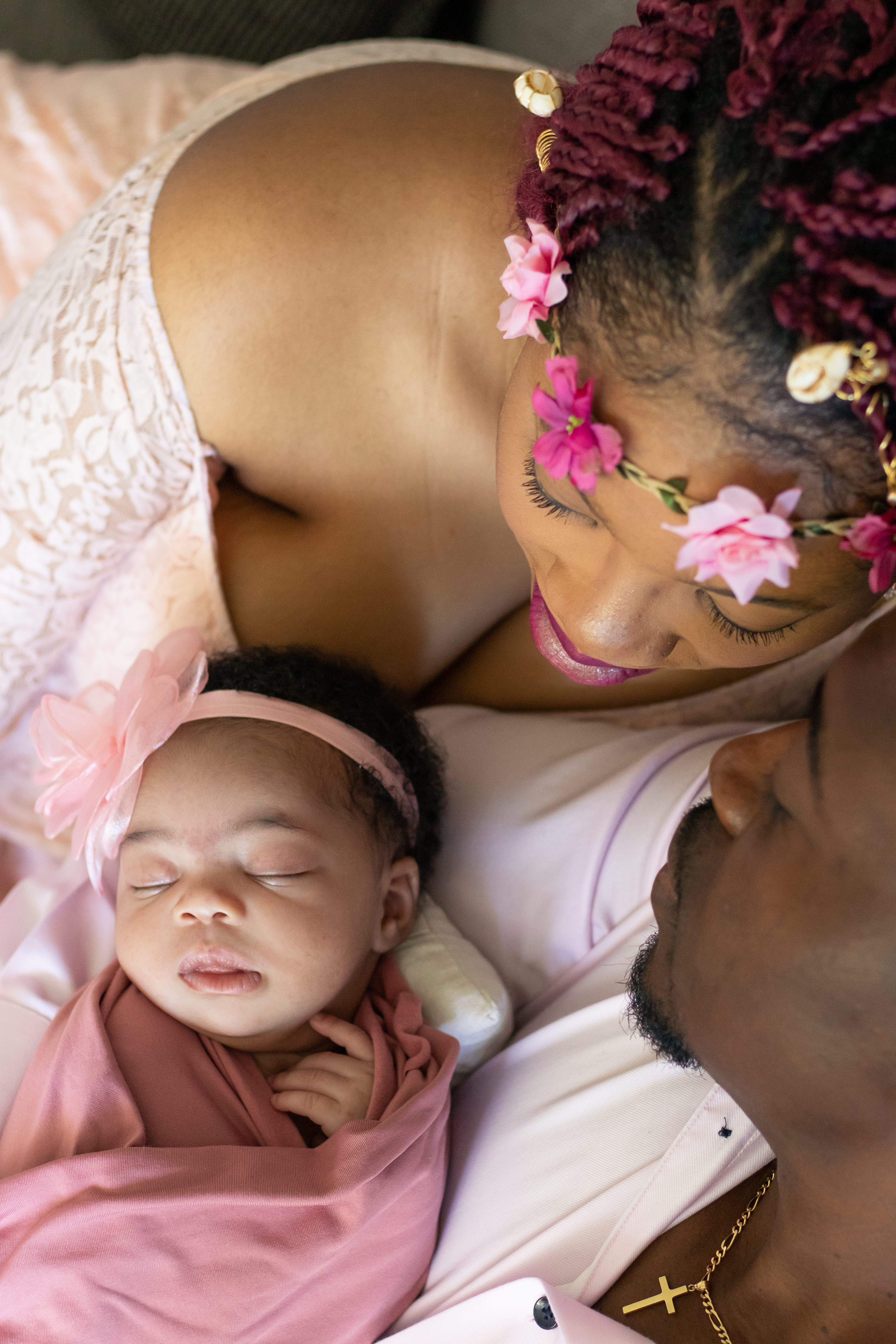 Couple snuggled looking at baby, view from above,