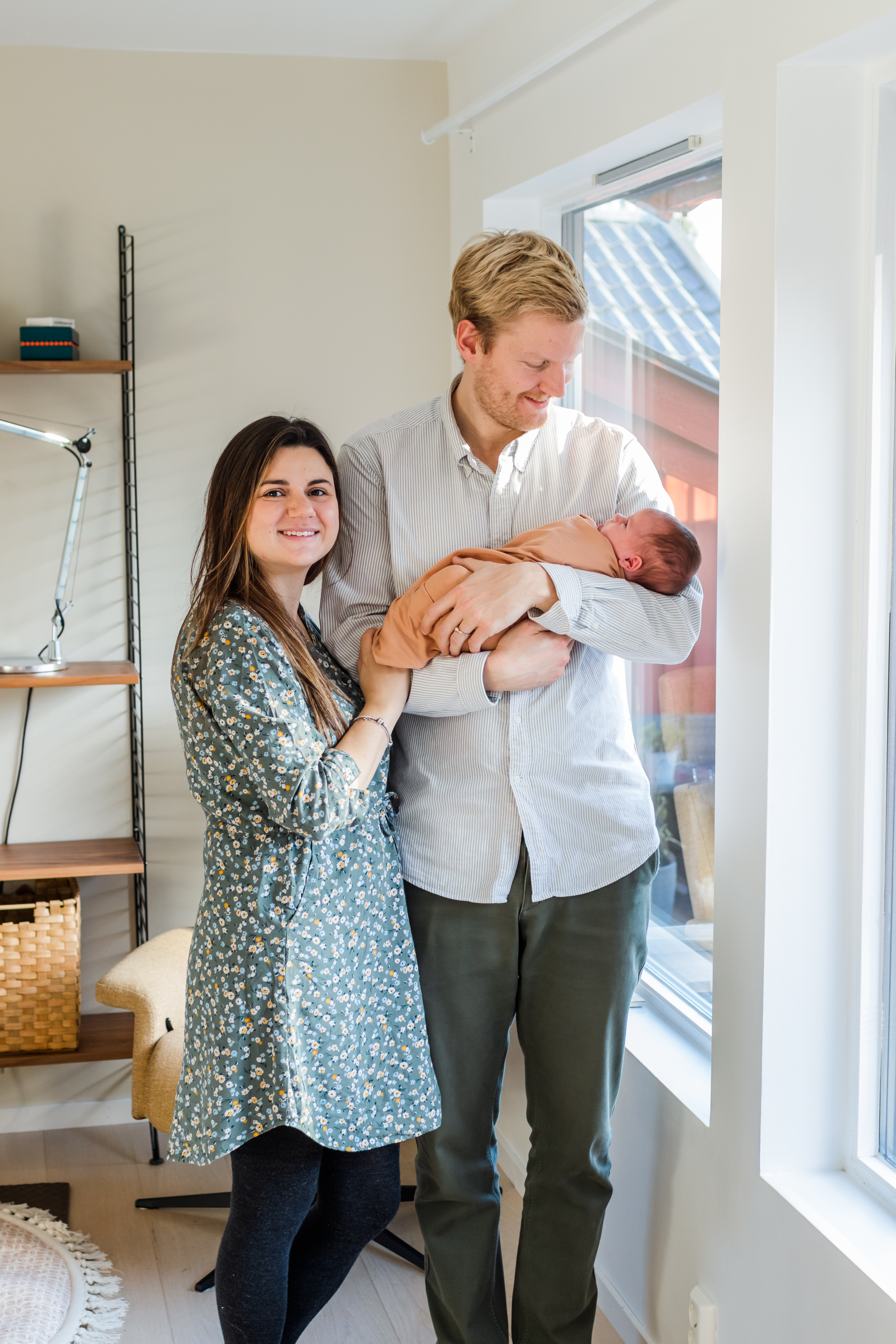 in-home newborn photographer in Creede, Dad holding and look at baby, mom smiling at camera