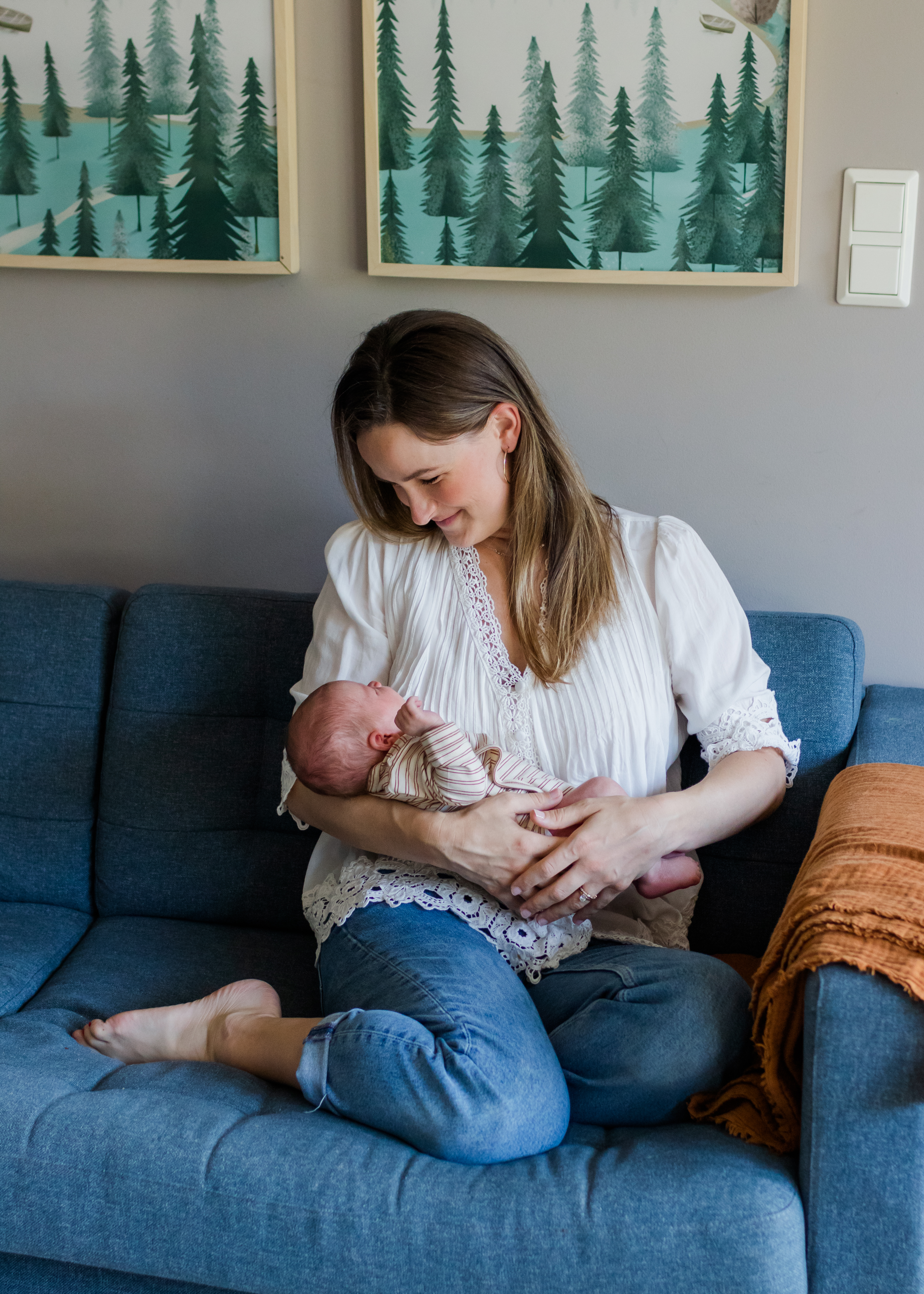 Mom smiling down at newborn, photographer near me