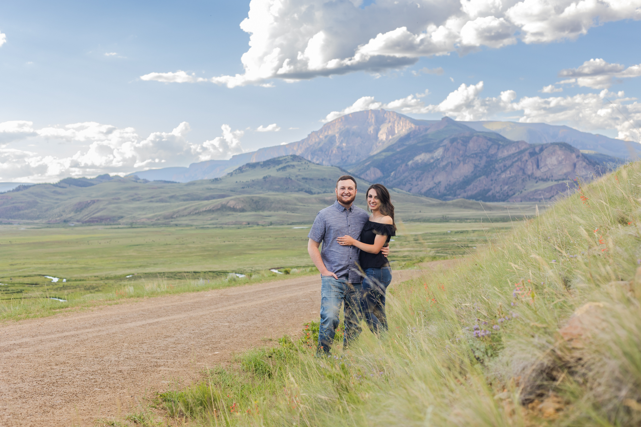Couple in wild flower field with mountains behind them Engagement photographer in creede, elopement photographer